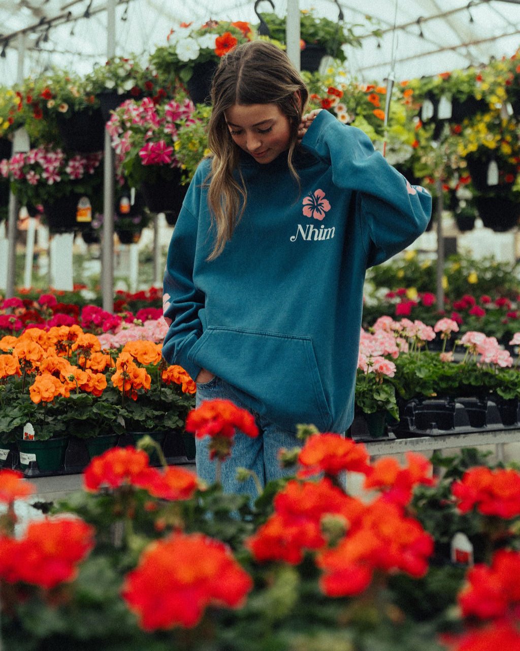 Your Presence is the air i breathe womens hoodie by nhim apparel christian clothing brand - image of a woman wearing the hoodie in a greenhouse full of flowers