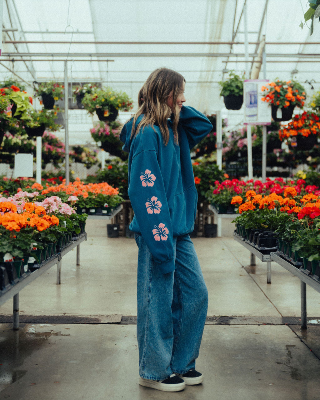 Your Presence is the air i breathe womens hoodie by nhim apparel christian clothing brand - image of a woman wearing the hoodie in a greenhouse full of flowers