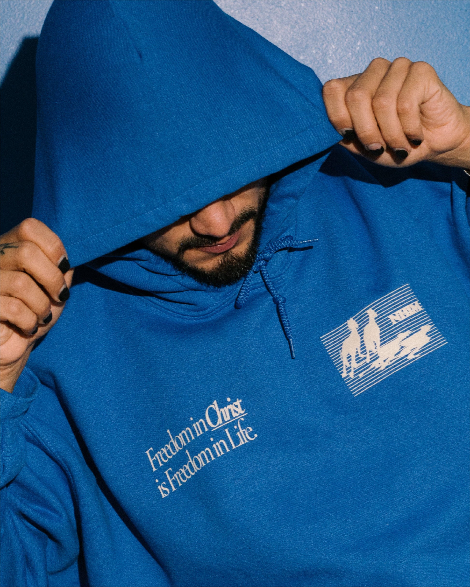 FREEDOM IN CHRIST HOODIE (ROYAL) on a model by NHIM Apparel Christian clothing brand