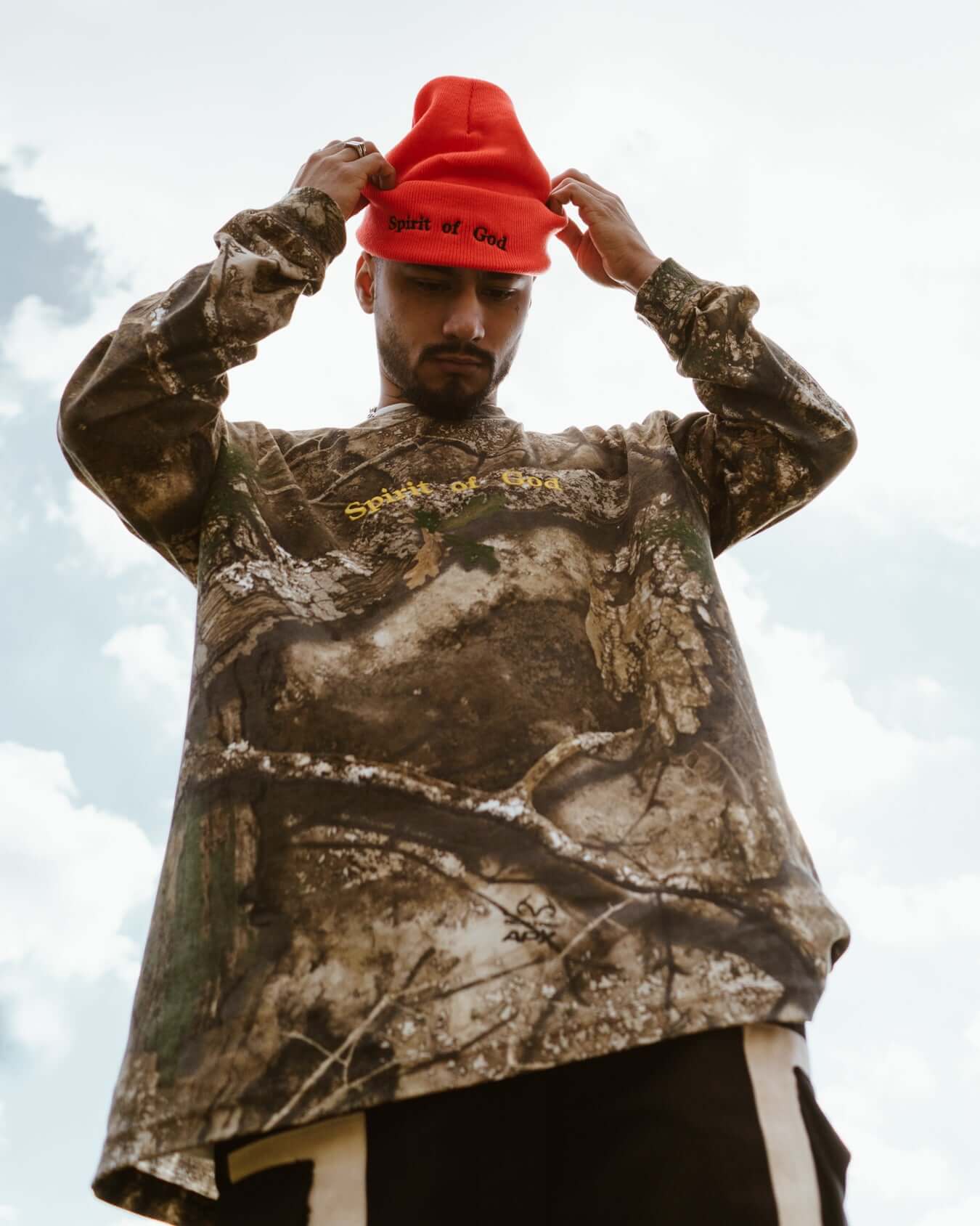 spirit of god orange hat and camo shirt on a model by nhim apparel clothing company