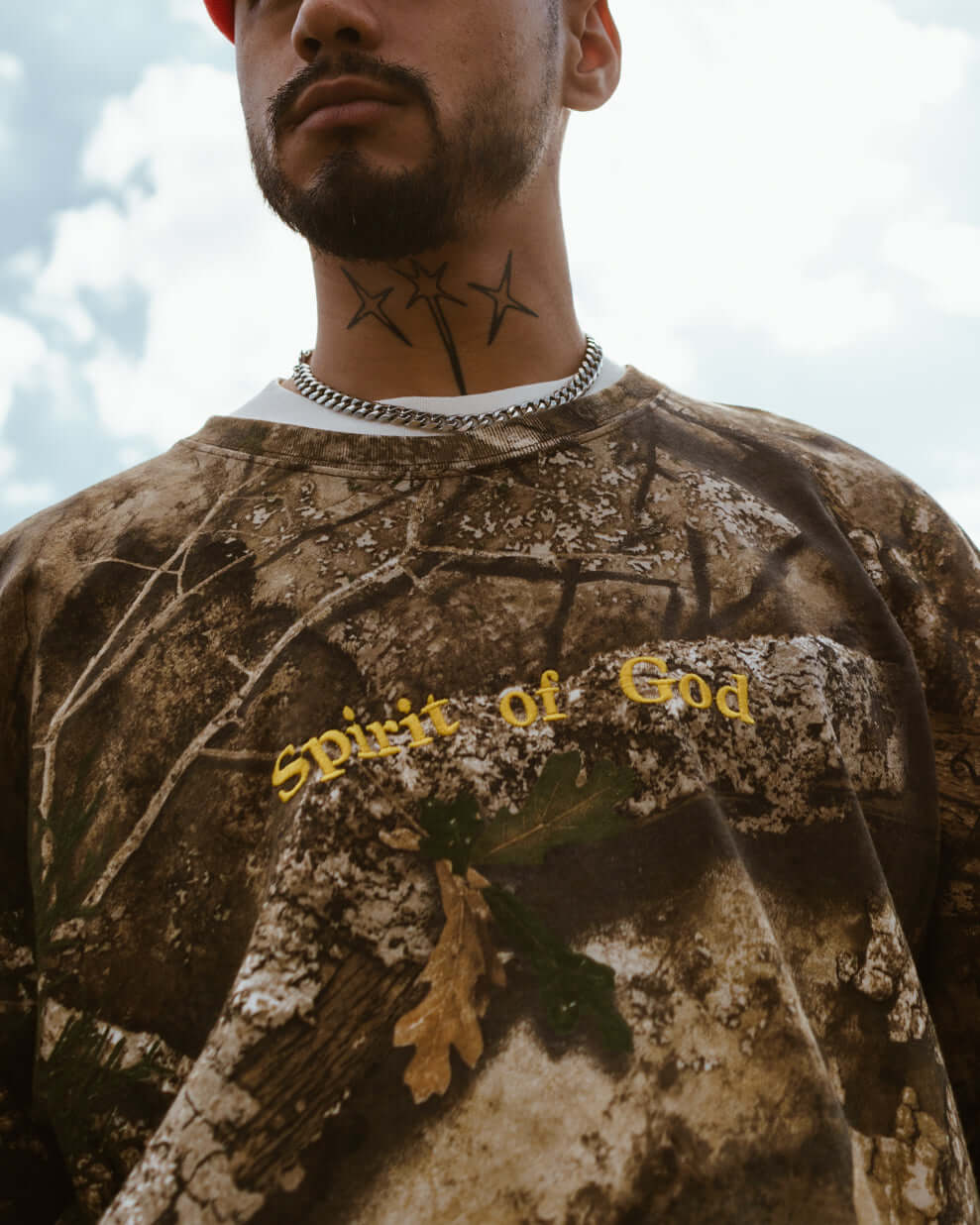 spirit of god orange hat and camo shirt on a model by nhim apparel clothing company