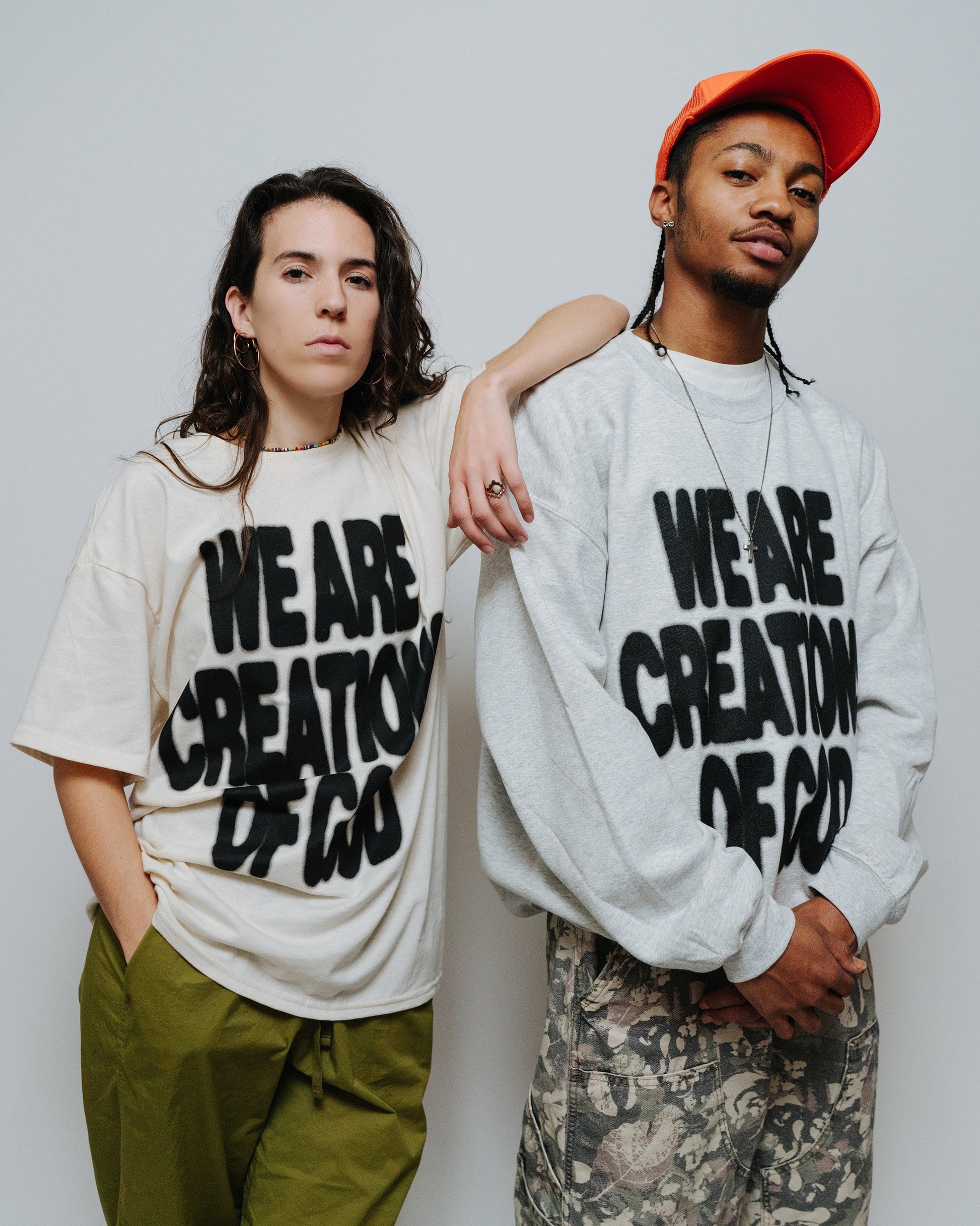 WE ARE CREATIONS OF GOD ash crewneck sweatshirt, orange hat, and natural tee by NHIM Apparel Christian clothing brand