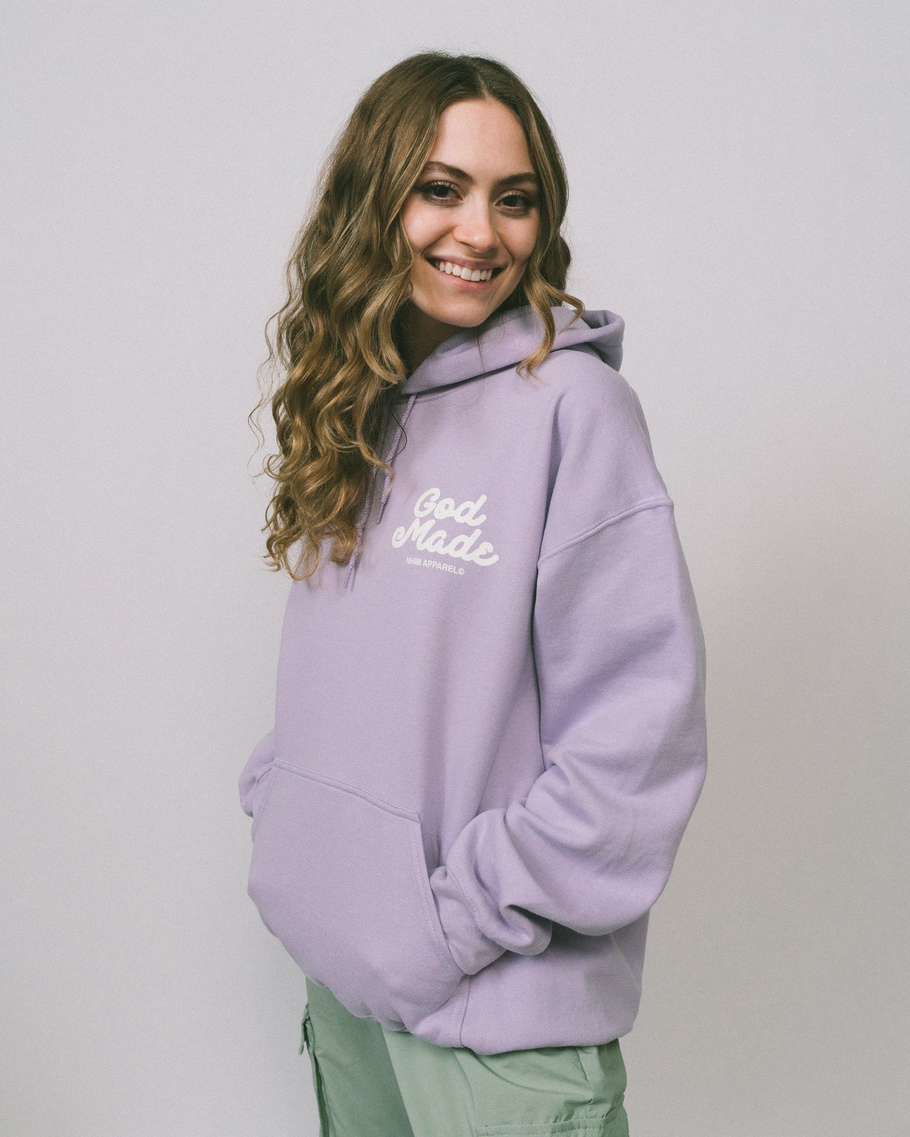 God Made lavender colored hooded sweatshirt with white graphic made by NHIM APPAREL christian clothing brand