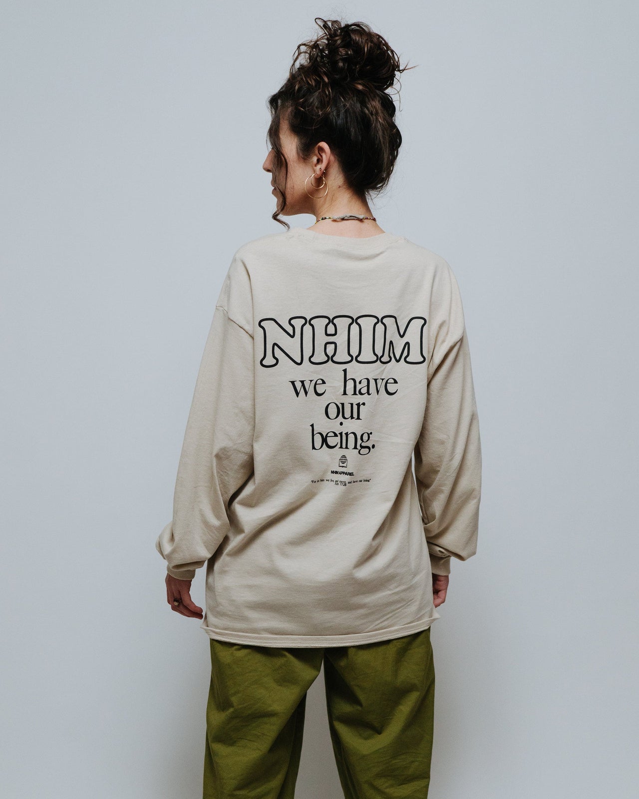 NHIM We have our being long sleeve shirt in sand. Mock picture. by NHIM Apparel Christian Clothing Brand. The name "NHIM" comes from Acts 17:28: “For in Him we live and move and have our being".