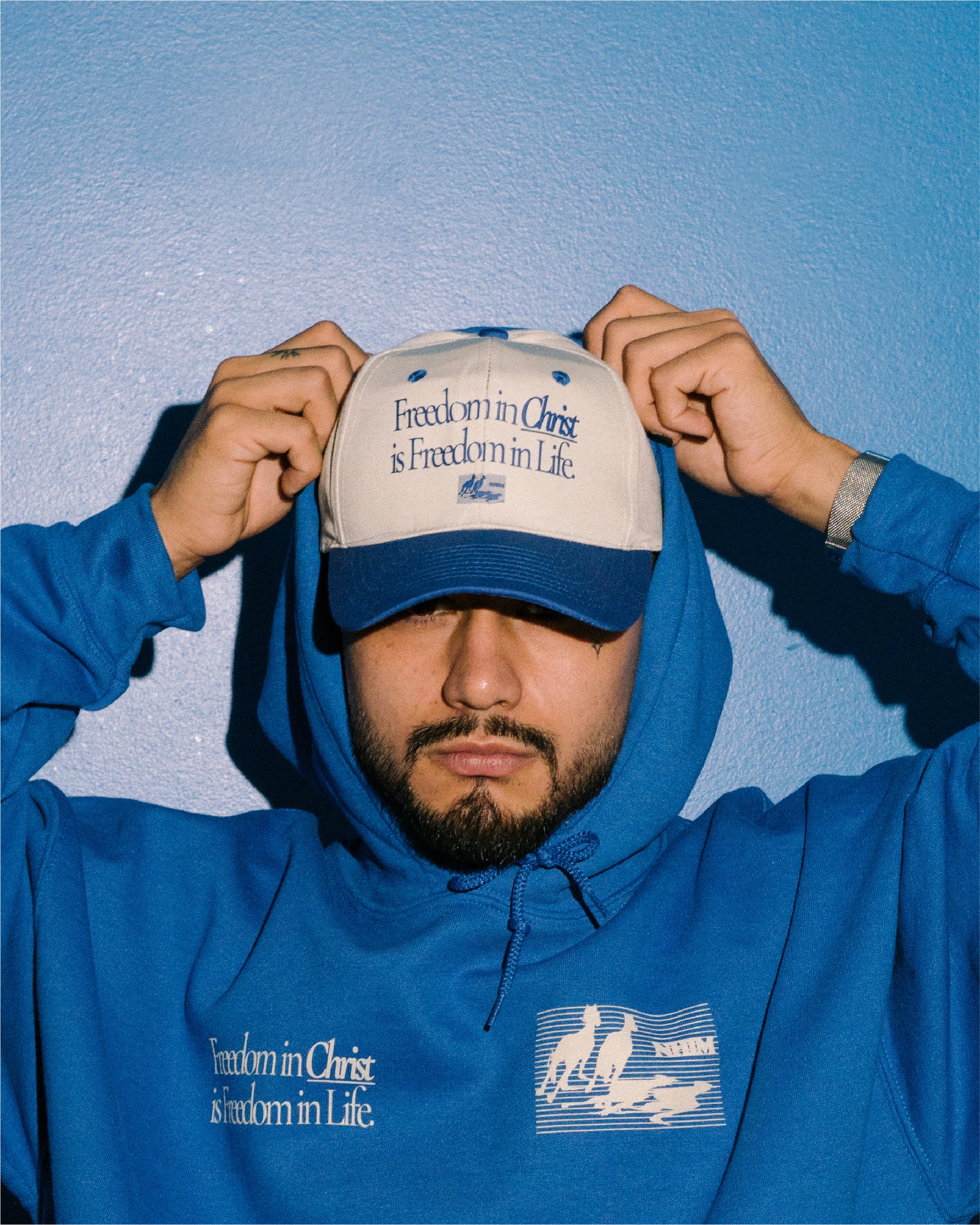 FREEDOM IN CHRIST IS FREEDOM IN LIFE two tone hat  and blue hoodie on a model by NHIM Apparel Christian clothing brand